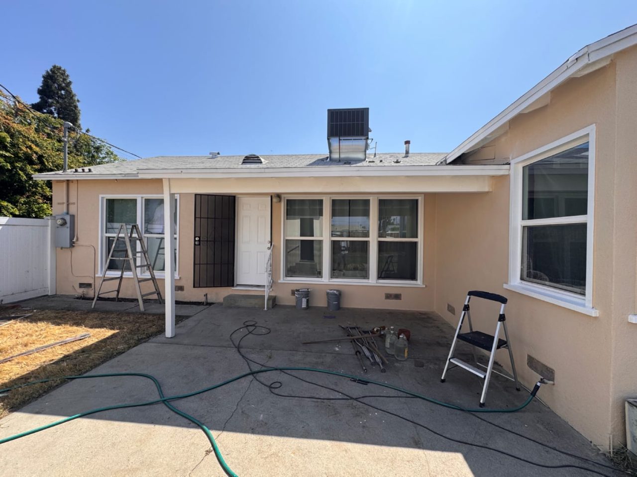 Exterior painting cost house with painters applying paint to stucco surface