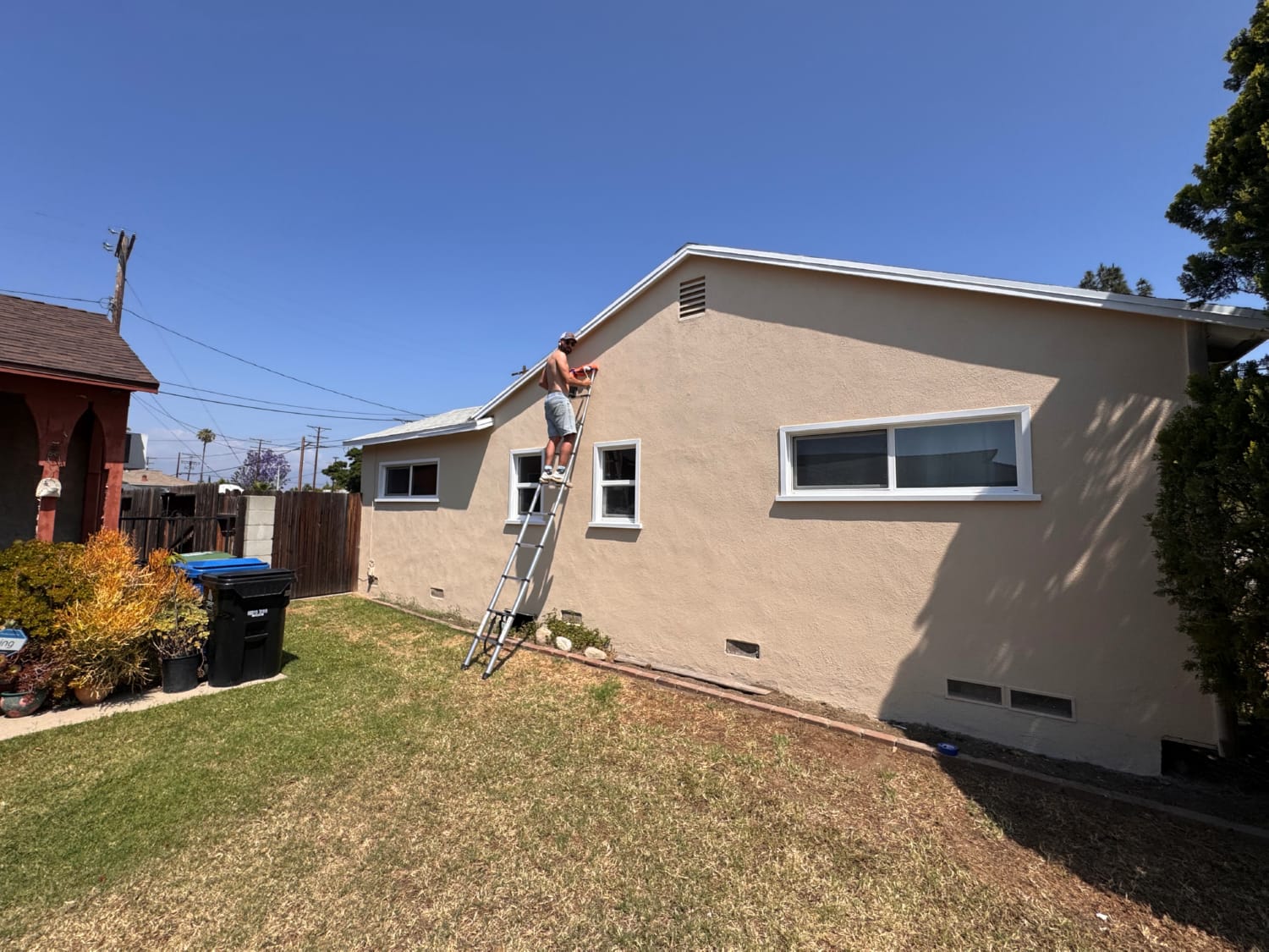 Exterior painting cost house with painters applying paint to stucco surface